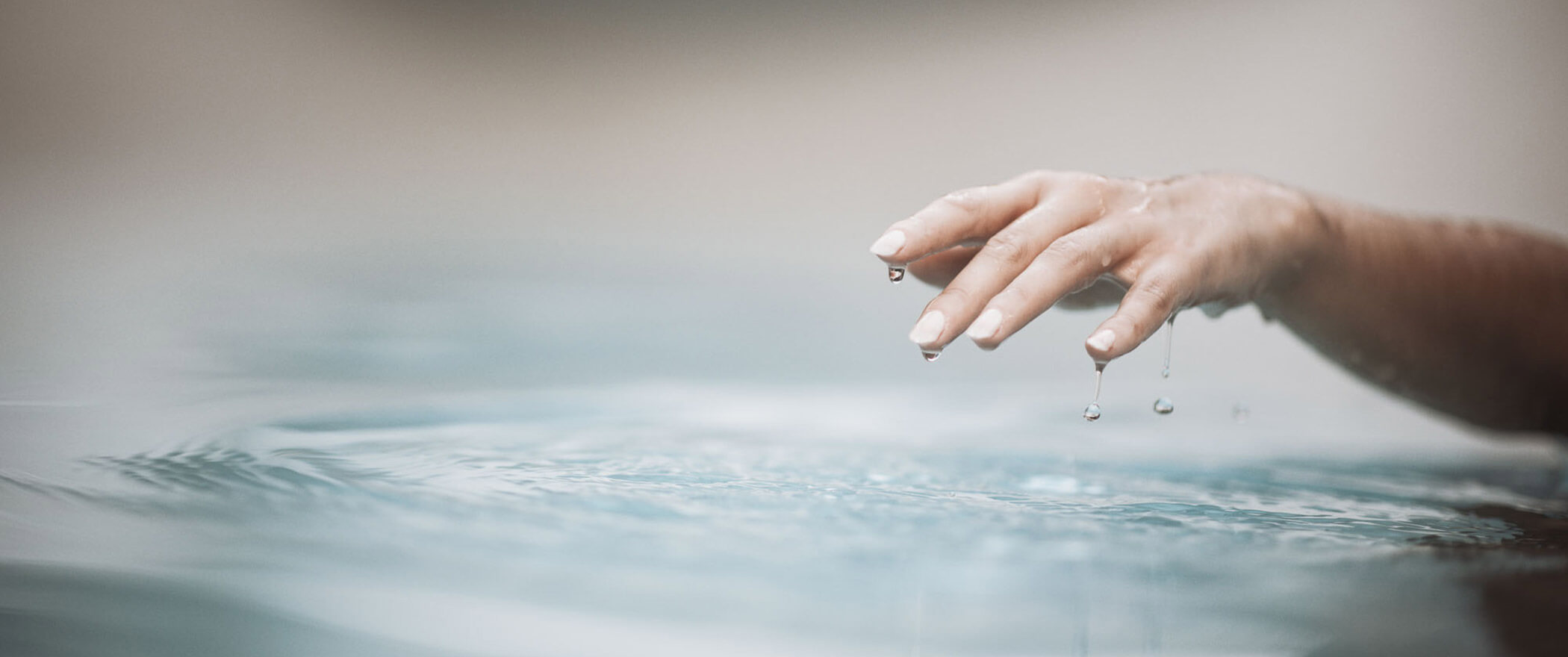 Ein Frauenarm gleitet aus dem Wasser vom Pool - Hotel Montis