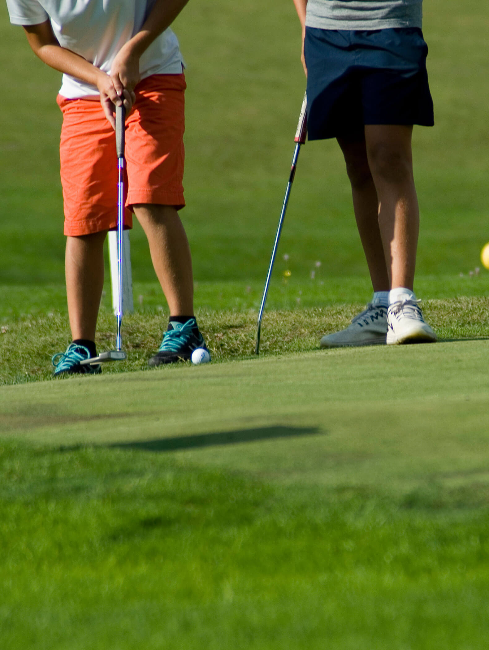 Die Beine von zwei Golfspielern beim Einlochen - Hotel Montis