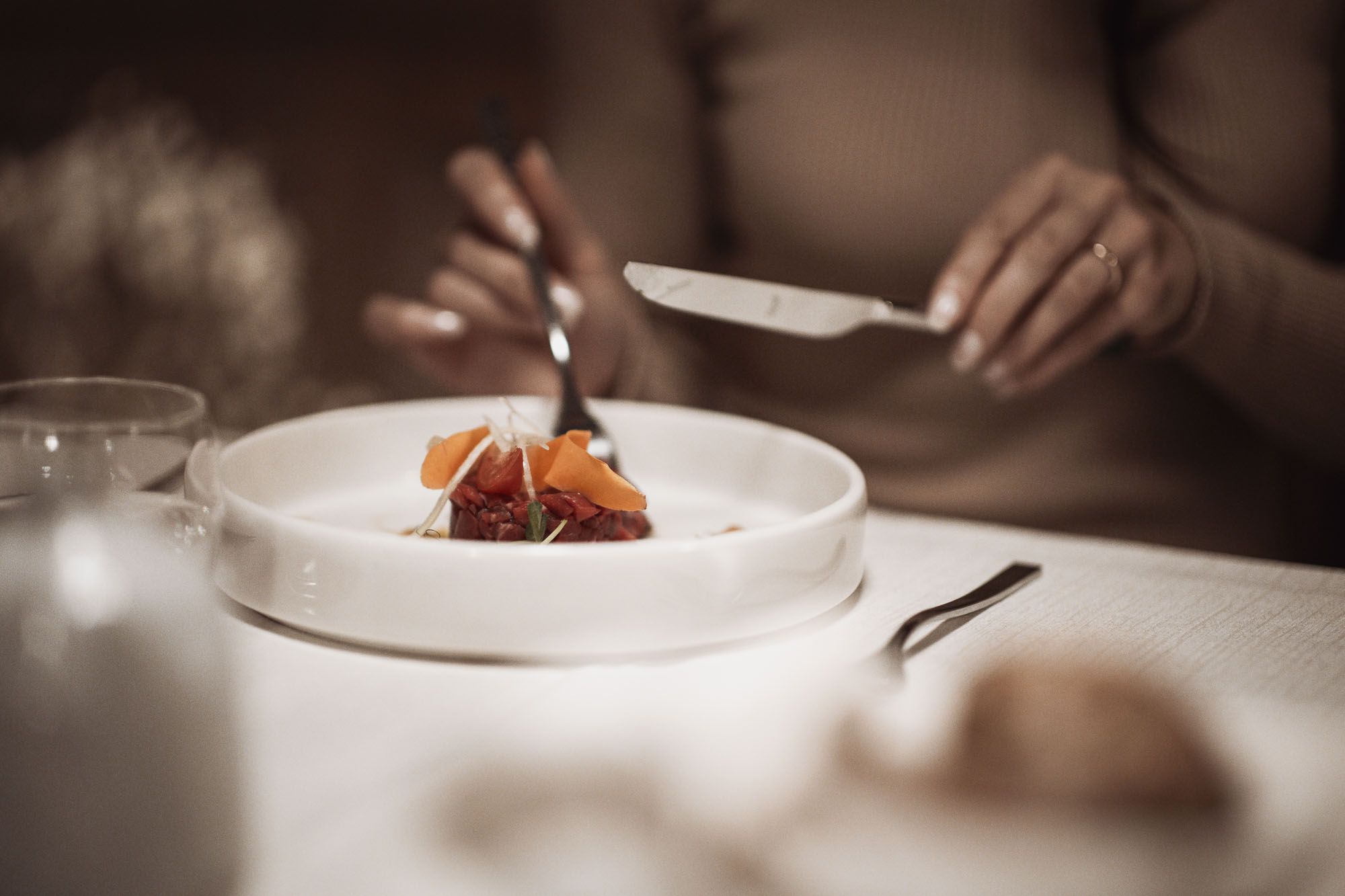Ein Gast genießt ein Tartar beim Abendessen - Hotel Montis