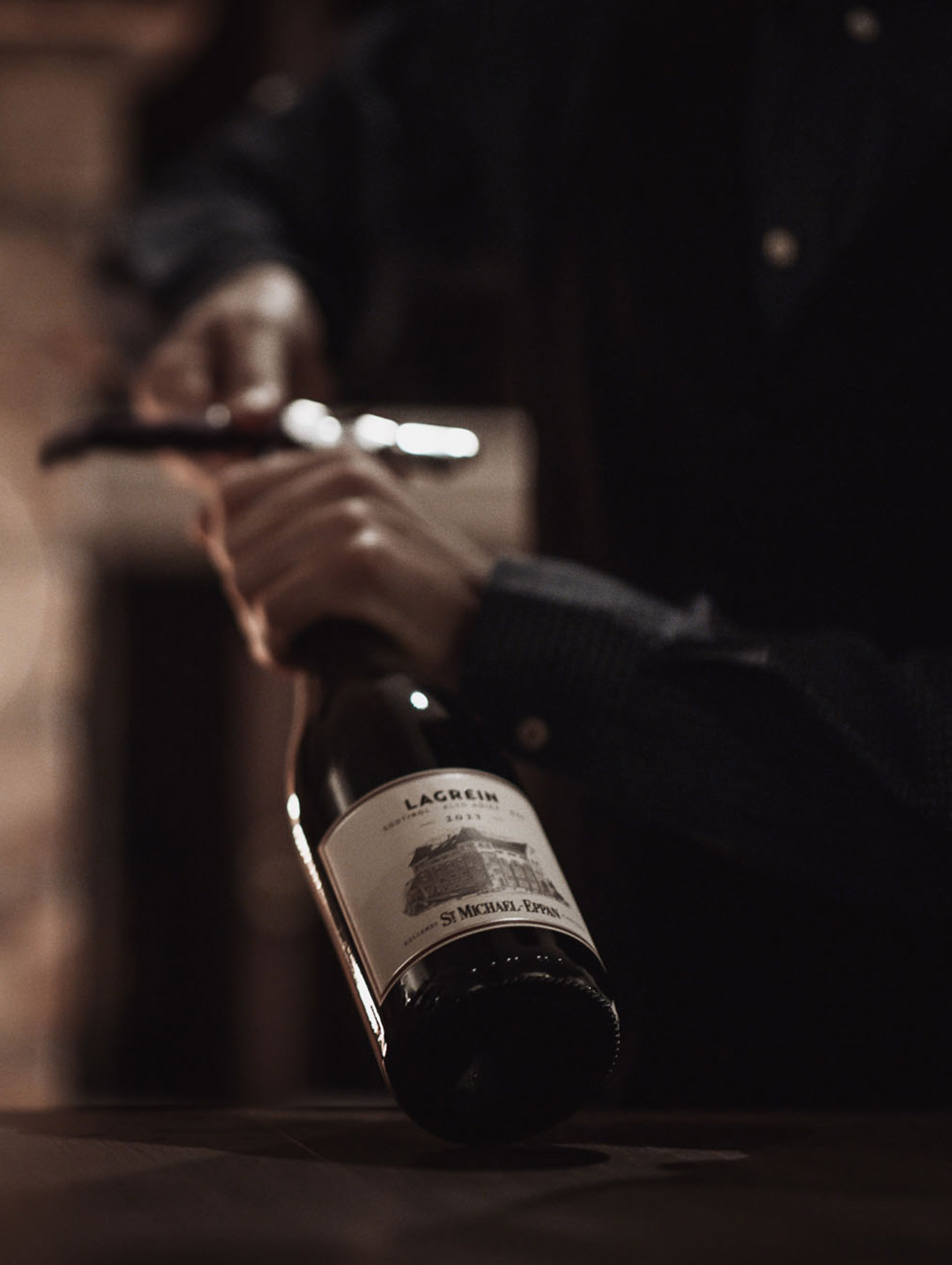 Ein Servicemitarbeiter öffnet eine Flasche Lagrein der Kellerei St Michael - Eppan - Hotel Montis