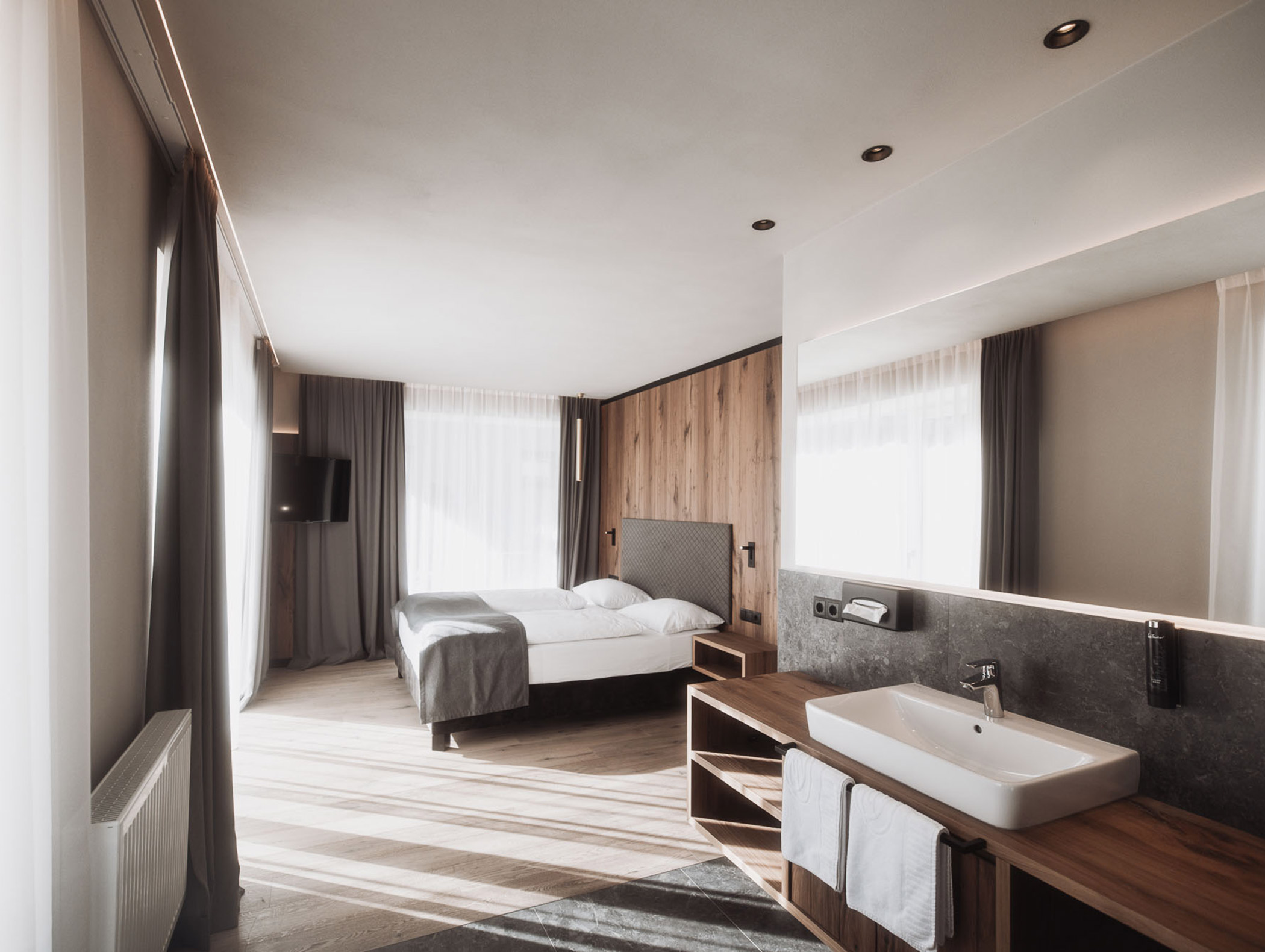 Schlafzimmer und offenes Badezimmer der Kronplatz Luxury Suite - Hotel Montis