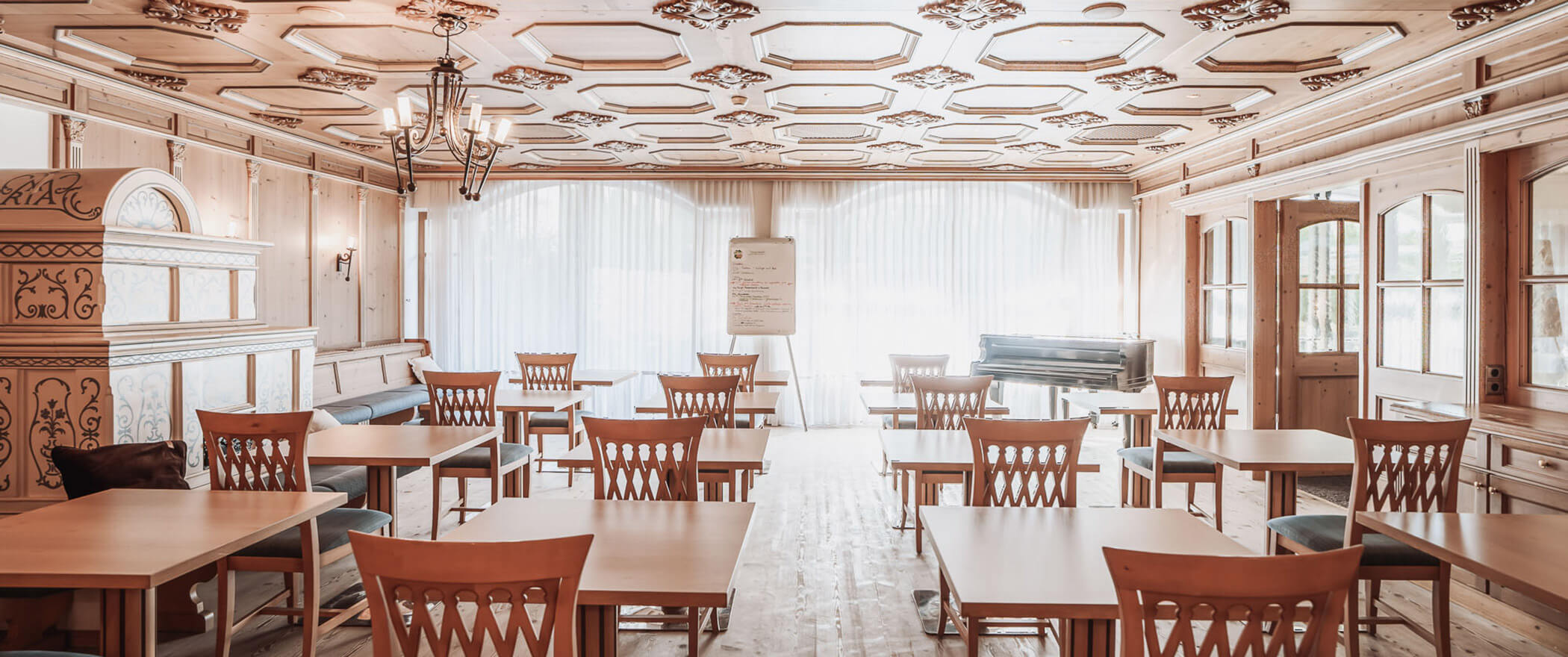 Seminar room with several tables and chairs and a flipchart board - Hotel Montis
