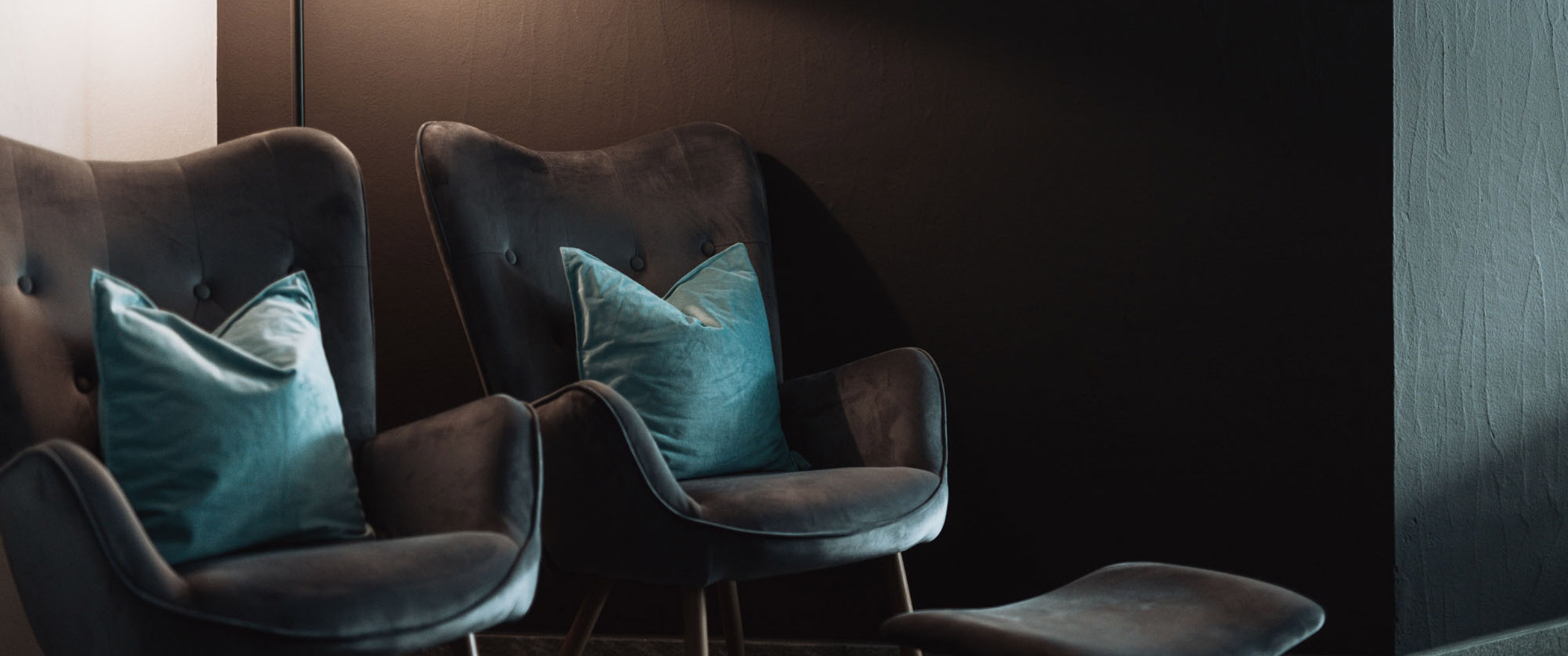 Dunkelgraue Sessel und blaue Polster - Hotel Montis